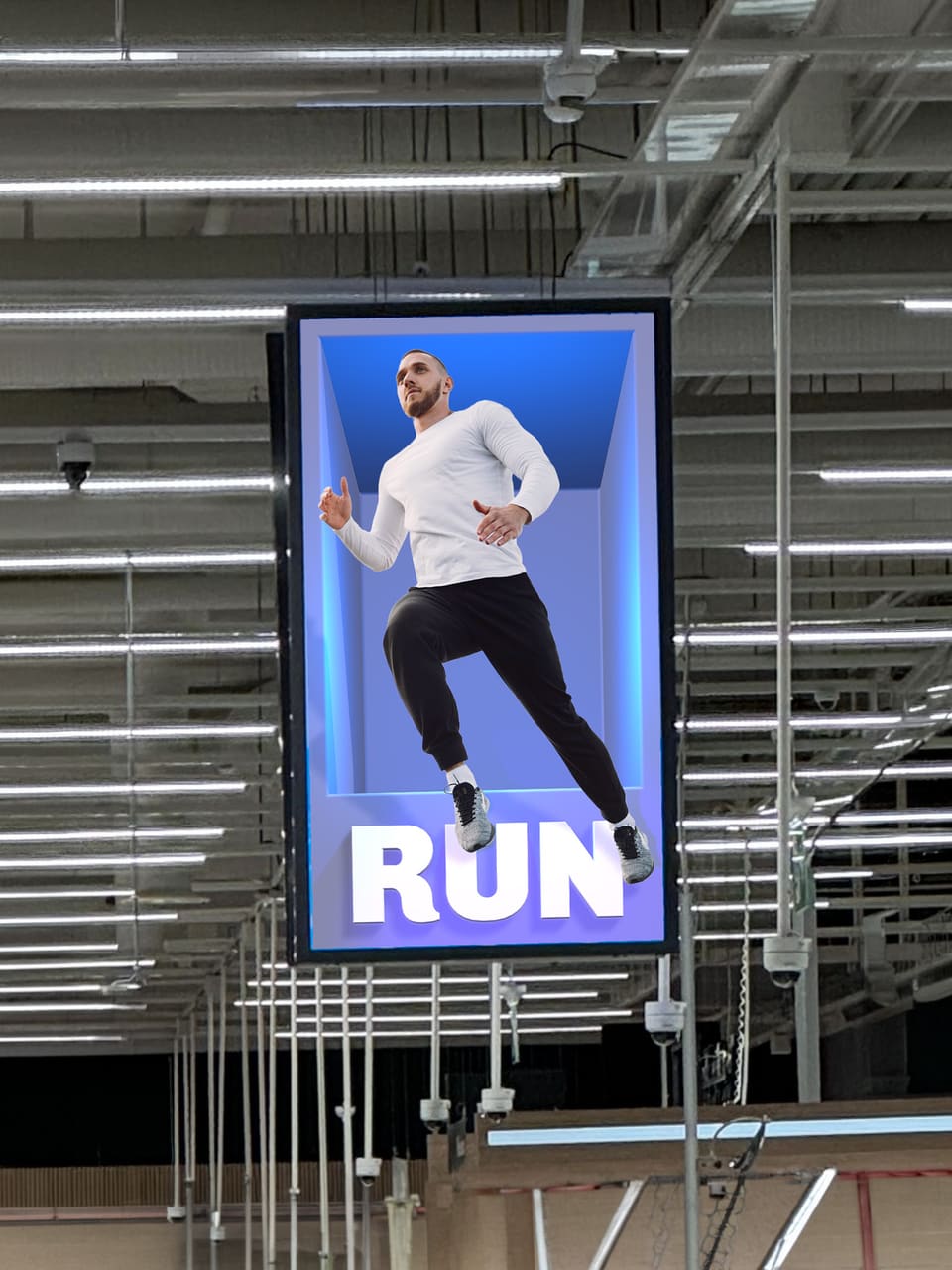 A tall display hanging in a warehouse aisle. A runner appears to leap out of a blue recess sunk into the screen, above the word RUN.