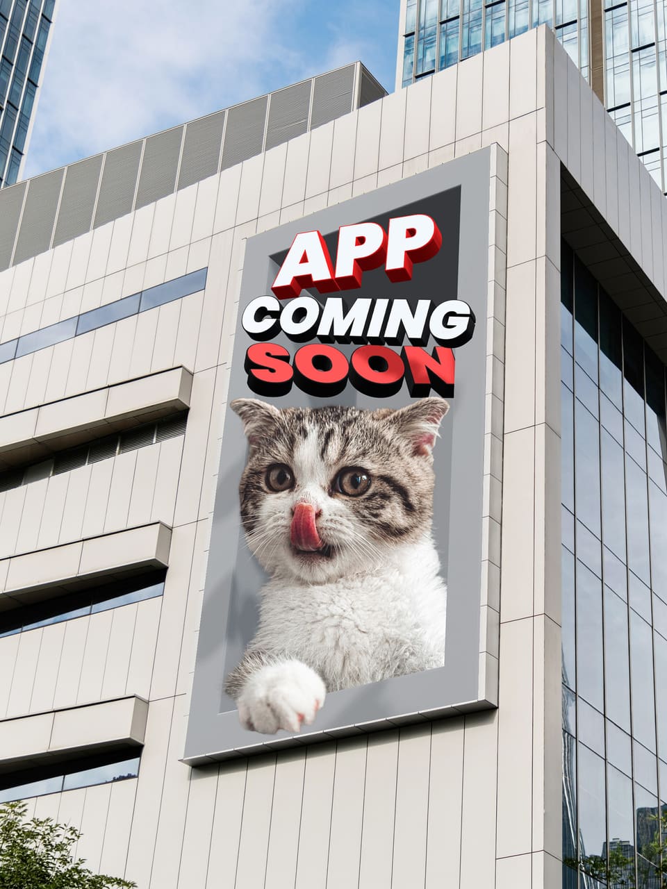A large screen on the corner of an office building. A cat leans out of the screen with one paw over the frame, under the words APP COMING SOON.